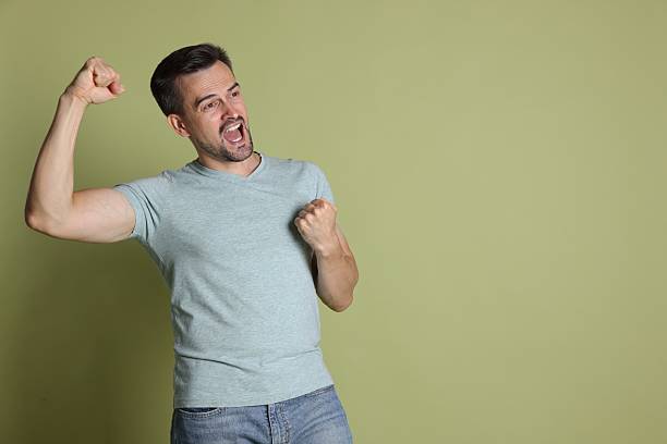 istock Portrait of happy winner on pale olive background, space for text 2219433063