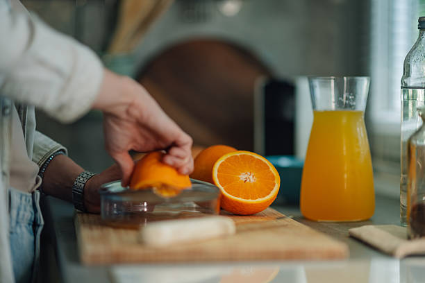 istock Woman squeezing fresh orange juice in the kitchen 2219433940