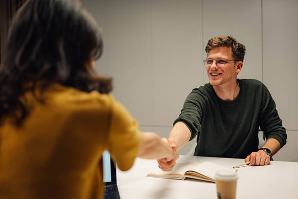istock Two young professionals shaking hands after a successful business meeting 2219434683