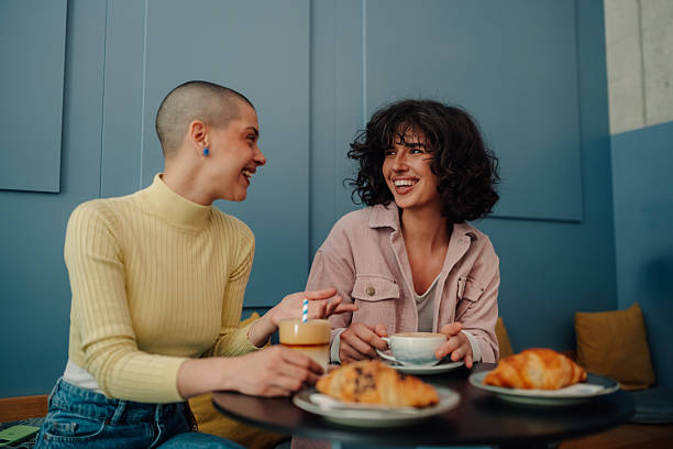 istock Two young women having breakfast and laughing together in a cafe 2219435527