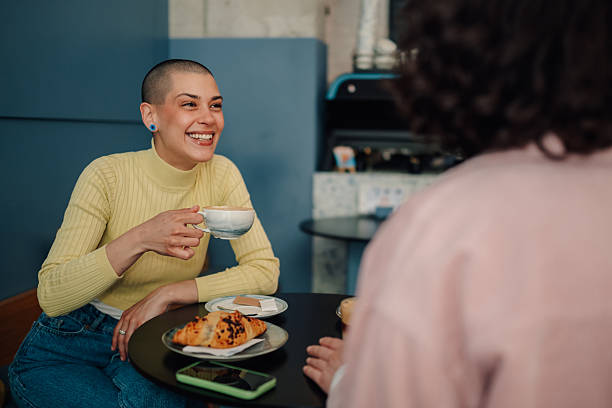 istock Cheerful young woman enjoying coffee and conversation at a cafe 2219435548