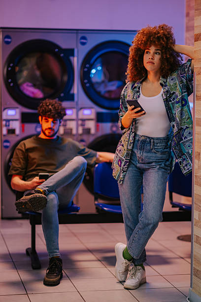 istock Young people waiting for laundry to finish while using smartphones 2219437518