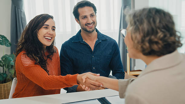 istock Financial advisor using tablet discussing about life insurance domestic finances and handshake agreement with young couple in living room at home. Financial planning and lifestyles concept. 2219440307