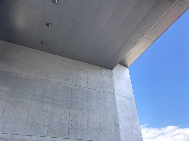 istock Architecture Minimal Exterior Wall Texture with blue Sky and clouds background. Light concrete building with open window frame against sky, Modern house with open space of construction geometric design 2219440540