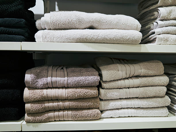 istock White and tan stack of towels sits on a shelf next to a black stack 2219442392