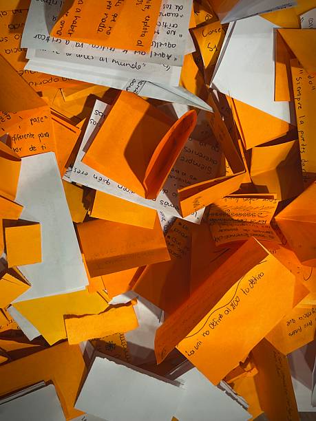 A scattered arrangement of orange and white handwritten paper notes, capturing brainstorming, organization, and creative expression with bold colors and varied handwriting styles.