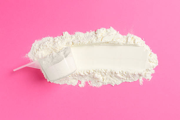 istock Protein powder and scoop on pink background, top view 2219444084