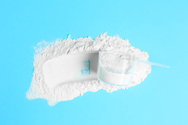 istock Protein powder and scoop on light blue background, top view 2219444085