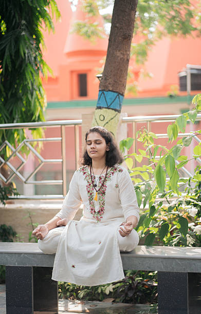 istock Woman practicing meditation in lotus pose outdoor at park 2219446598