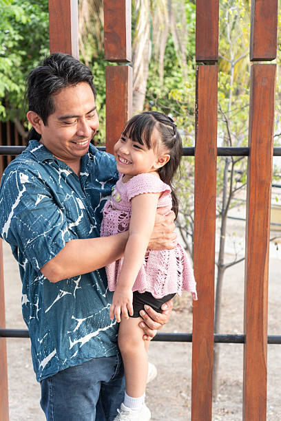 istock Hispanic father holding and smiling at his daughter 2219452096