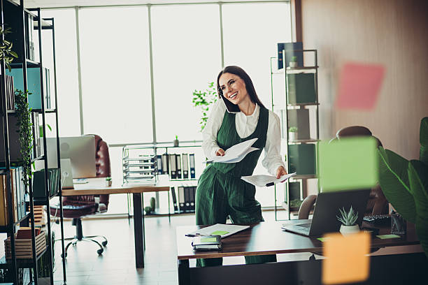 istock Elegant businesswoman engaging in multitasking while working in a modern office environment and exuding professional charm 2219452907