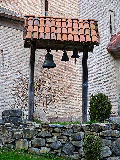 istock Three bells hanging in a belfry with a tiled roof 2219453424