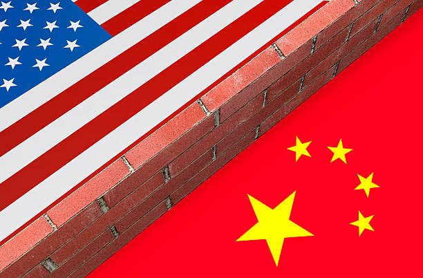 istock Brick wall dividing USA and China flags symbolizing trade war 2219453506