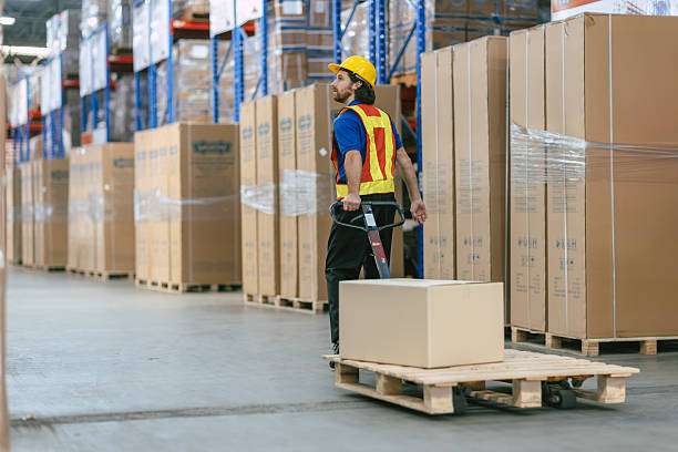 istock caucasian worker in a warehouse using hand pallet truck jack stacker to moving pallets good cargo, 2219455475