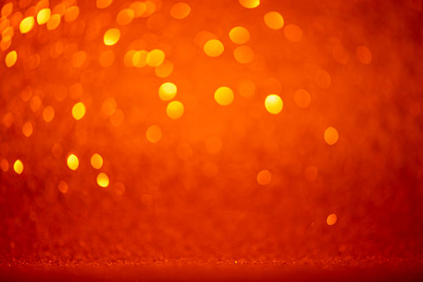 A beautifully abstract, defocused image with softly glowing orange color, golden bokeh, and a delicate textured surface. Perfect for fall celebration, Thanksgiving - Holiday, or romantic anniversary content. Includes elegant copy space and works well as a premium design element for web banner, slide show, or party - social event uses.