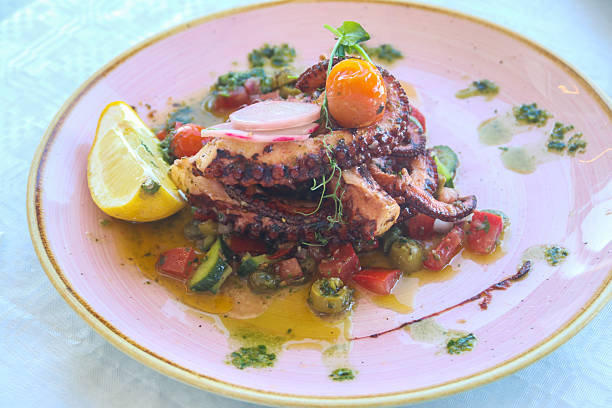 istock Delicious octopus dish served with lemon, vegetables and sauce in a restaurant 2219458940