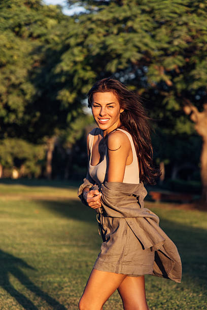istock Confident young woman outdoors enjoying sunlight in a natural park setting 2219459090