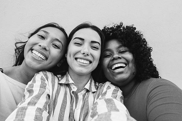 istock Group of three latin friends having fun doing selfie with mobile phone app - Generation z lifestyle and influencer concept - Main focus on center face - Black and white editing 2219460068