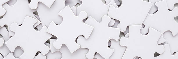 istock Different many white puzzle pieces background. Wide banner. Closeup. Top down view. 2219463145