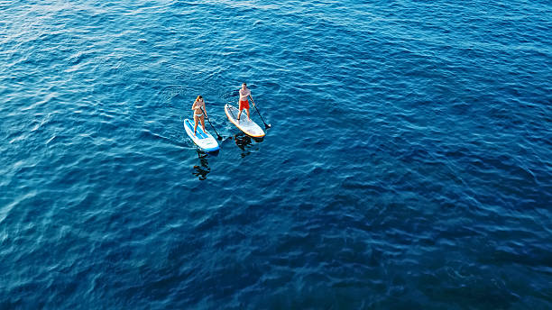 istock Two paddleboarders glide on calm blue waters 2219467630