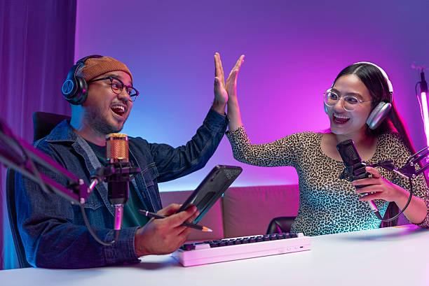 istock Two young asian streamer host making live podcast with condenser microphone and tablet at broadcast home studio. Content creator and social media influencer creating digital content. 2219468213