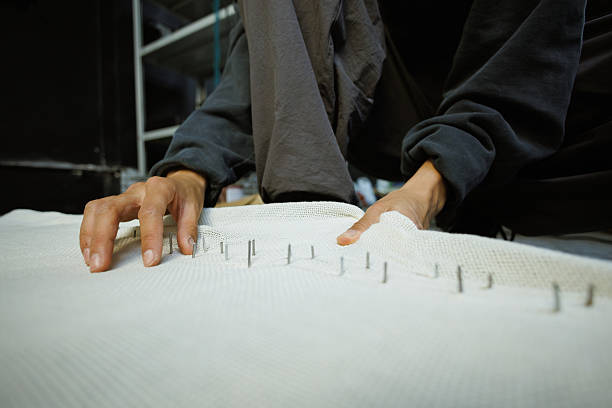 istock Close up of craftswoman pulling carpet canvas on frame with nails 2219468337