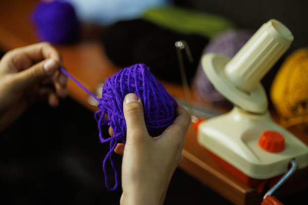 istock Craftswoman holding thread yarn near blurred ball winder 2219468823