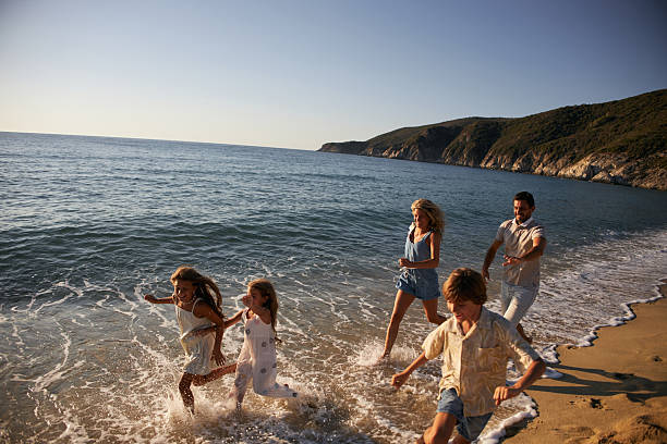 istock A family run down a tropical paradise beach during sunrise 2219472634
