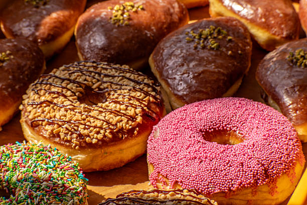 istock Assorted glazed and decorated donuts on a wooden tray in a bakery 2219476488
