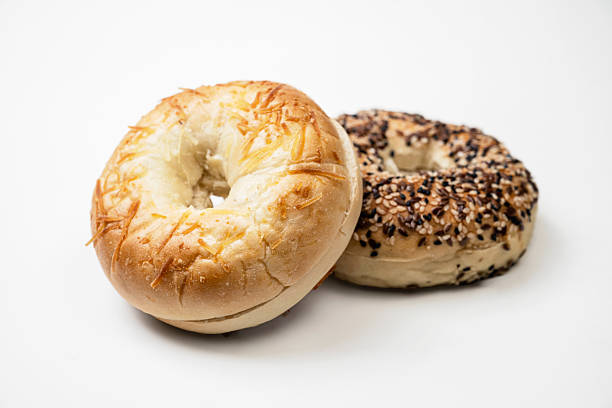 istock Closeup view of two bagel breads with different kind isolated over white background 2219479720