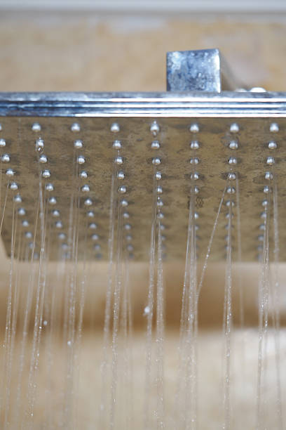 istock Water droplets cascade from a modern showerhead in a bathroom 2219479806