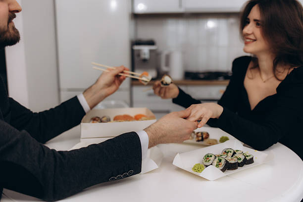 istock Romantic Couple Sharing Sushi Meal at Home on a Delightful Evening 2219482010