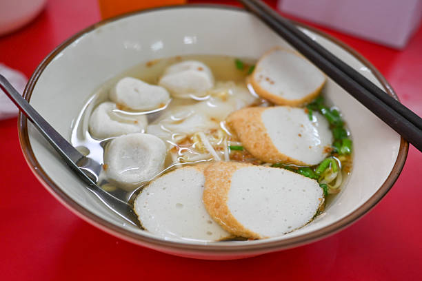 boiled Chinese yellow egg noodles with entrails and fish ball in soup on bowl