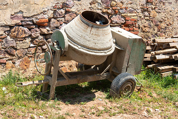 Dusty old concrete mixer machine stored indoors at a construction site