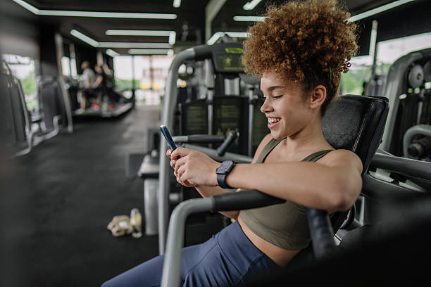 istock Woman texting on phone during gym downtime 2219491477