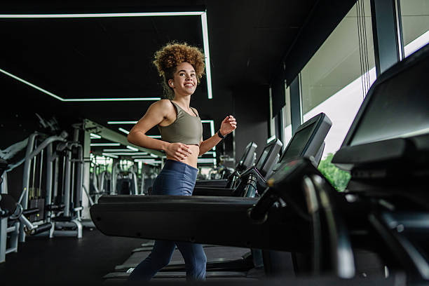 istock Cheerful woman checking smartwatch during treadmill run. 2219493731