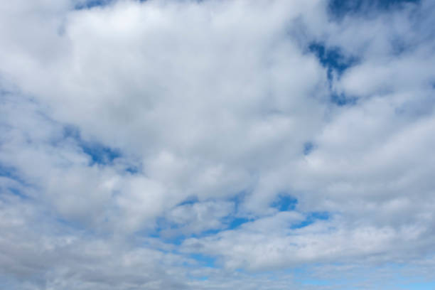 A serene view of fluffy white clouds scattered across a vibrant blue sky, creating a peaceful and tranquil atmosphereâperfect for nature, weather, or background themes.