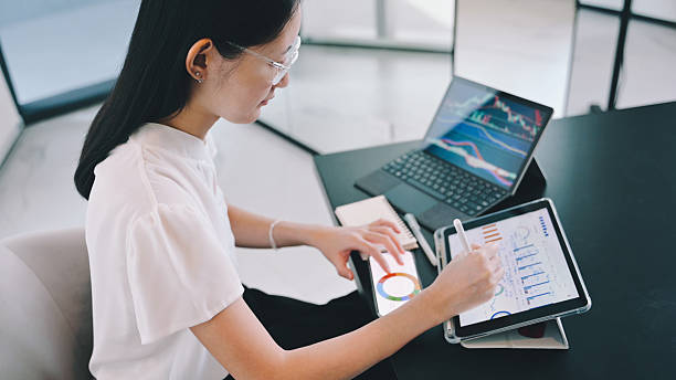 istock female investor using tablet and phone simultaneously to track market multitasking with fintech devices to manage investments and respond to stock market changes 2026 2219494855