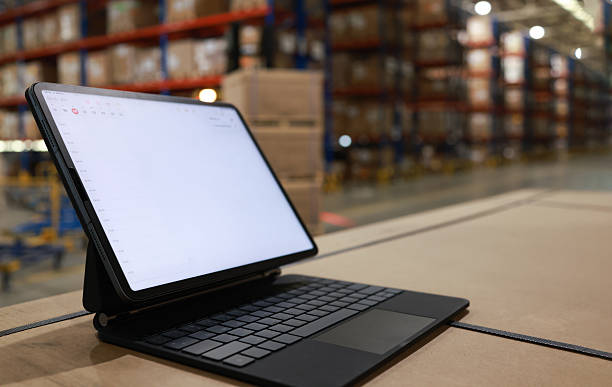istock Digital tablet or laptop with white screen for job operating in High rack warehouse , logistic management and technology 2219499872