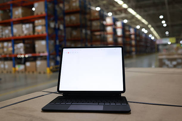 istock Digital tablet or laptop with white screen for job operating in High rack warehouse , logistic management and technology 2219499874