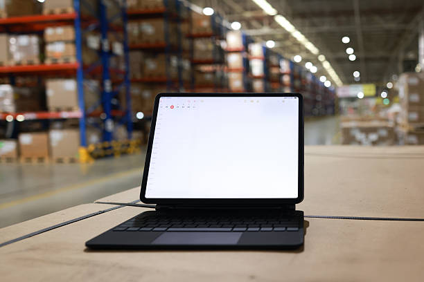 istock Digital tablet or laptop with white screen for job operating in High rack warehouse , logistic management and technology 2219499899