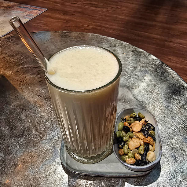 Indulge in a deliciously creamy drink that is beautifully complemented by a colorful and crunchy snack mix on the side