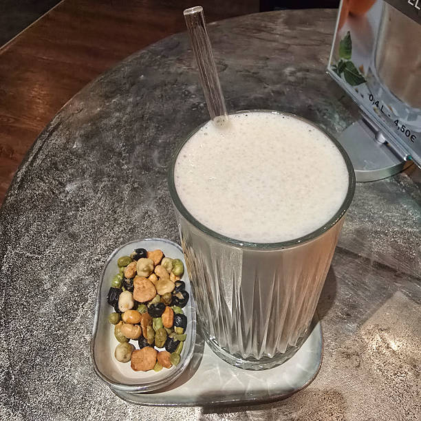 A delicious and refreshing smoothie paired with a delightful variety of crunchy nuts set on a chic cafe table