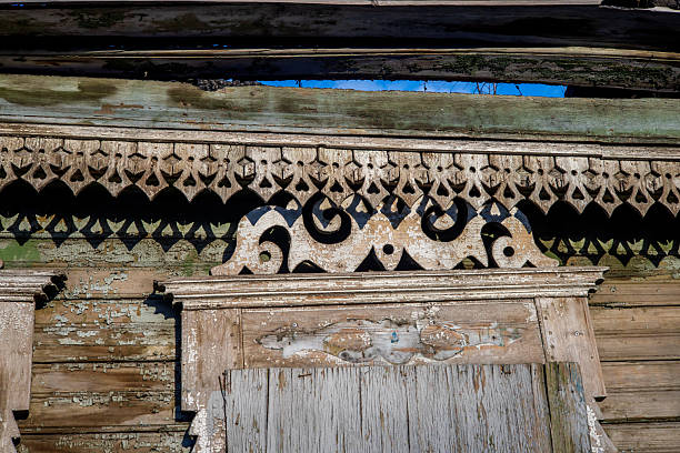 Windows with carved shutters and frames on an old rural house. Beautiful hand-made patterns. Wooden architecture.