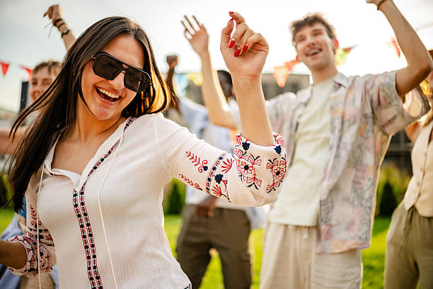istock Vibrant crowd dancing joyfully at an outdoor concert during sunset 2219502462