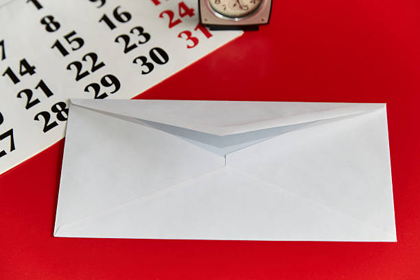 White mail envelope and paper calendar on a red background, regular mailing, holiday greetings, monthly mail transfers, mailing list.