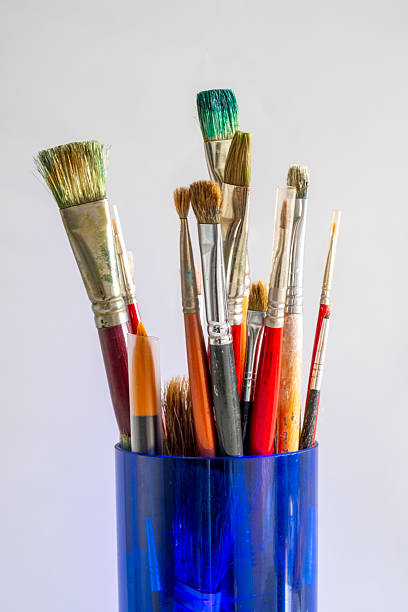 istock Oil paint brushes of various sizes in a blue glass container 2219504485