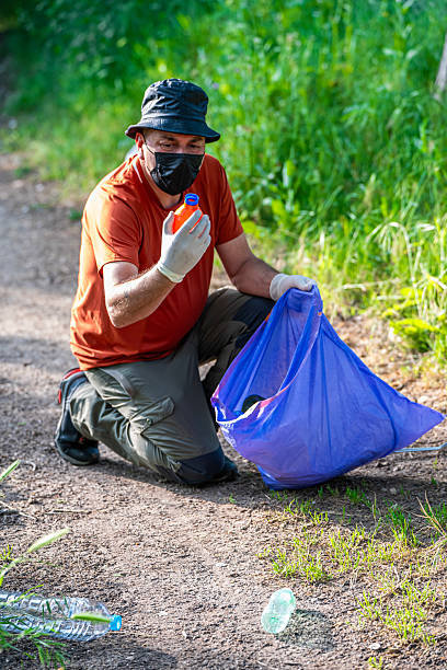 istock Volunteer environmentalist collecting trash in the forest, environmental cleanup 2219505356