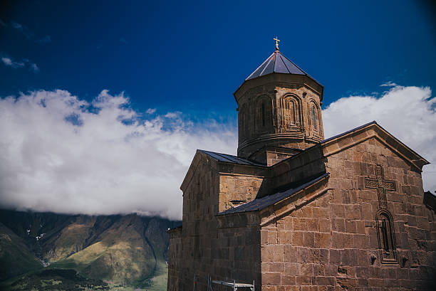 The iconic Gergeti Trinity Church near Stepantsminda, Georgia, standing majestically under Mount Kazbek in the Greater Caucasus, surrounded by dramatic mountain landscapes.