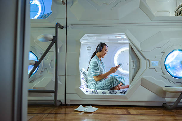 istock Woman relaxing in a futuristic sleep pod while using a smartphone 2219509427